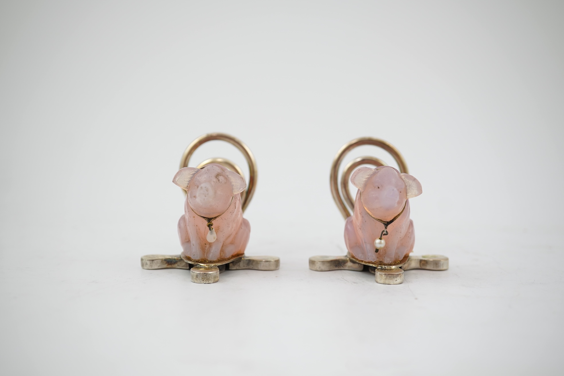 A cased pair of unusual Edwardian silver and pink glass mounted menu holders, by William Comyns, each modelled as a seated pig with collar